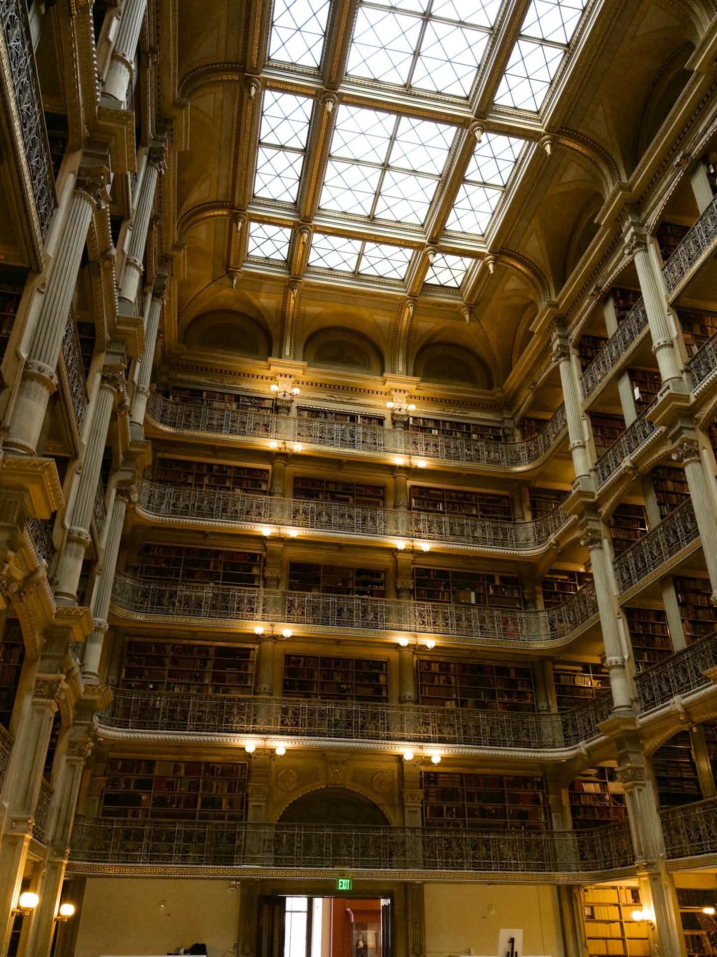 Biblioteca antiga com cinco andares de estantes e uma claraboia